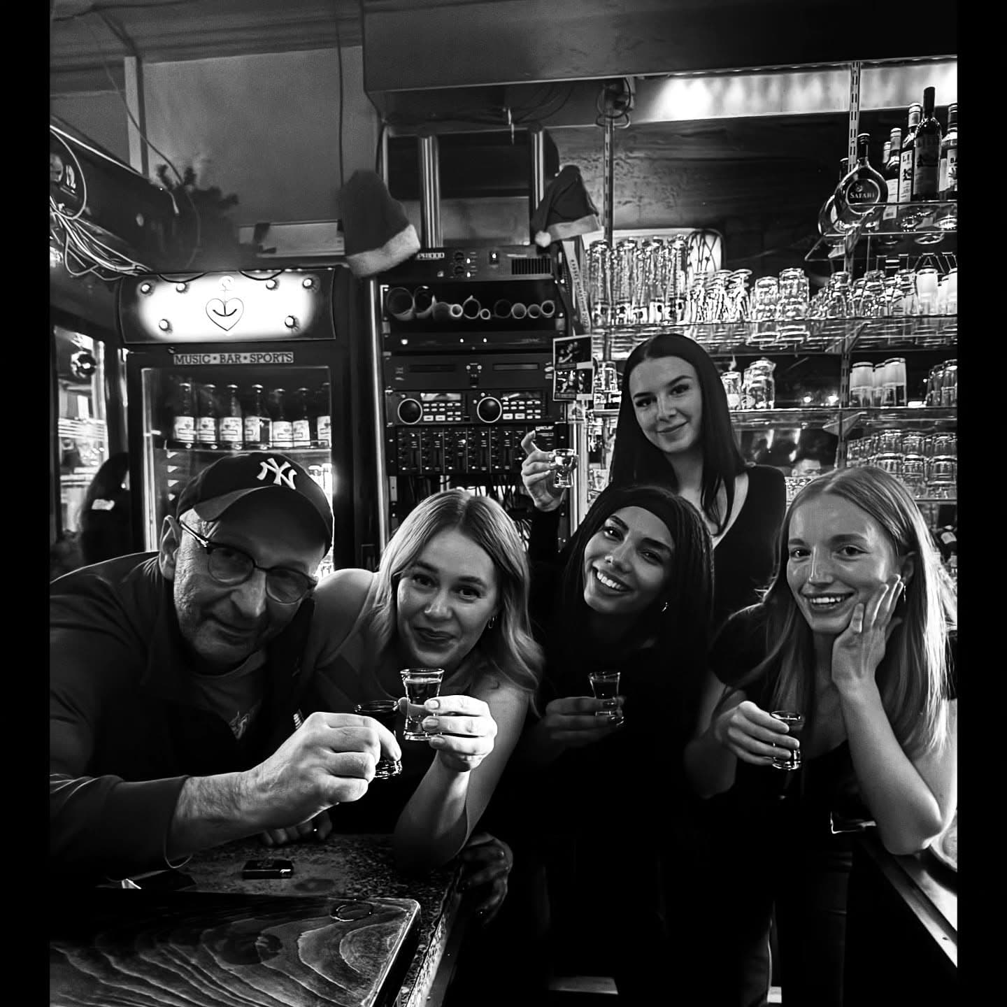 Schwarz-Weiß-Aufnahme einer Gruppe mit Shots an der Bar