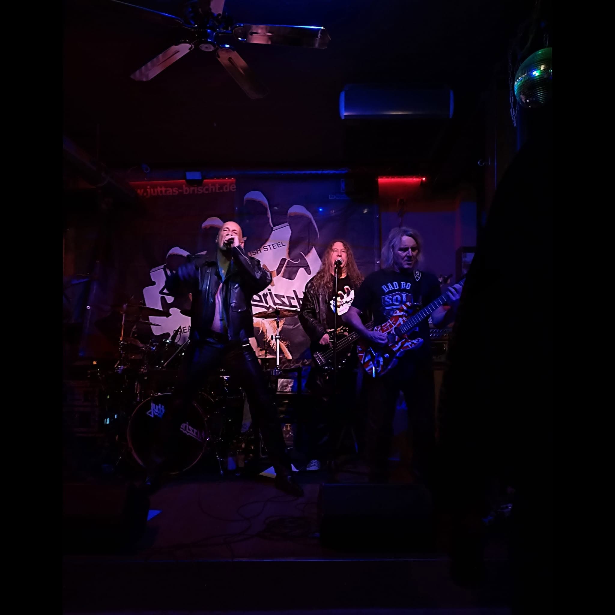 Band im blauen Licht unter einer Discokugel