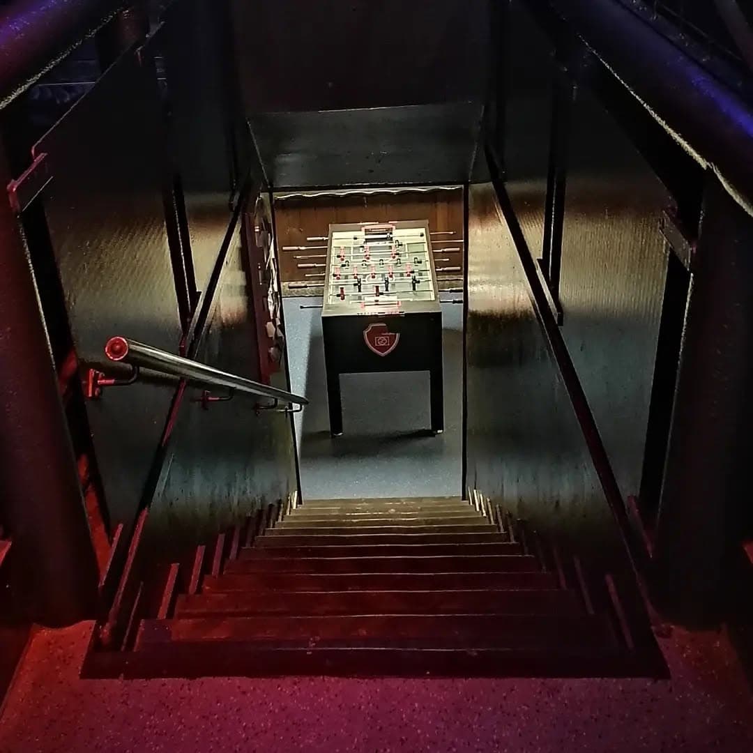 Treppenabgang zum beleuchteten Kickertisch